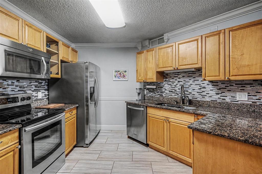 1550 South Belcher Road, Unit 525 Clearwater, FL 33764 - Photo 11 of 28 a kitchen with stainless steel appliances granite countertop a sink stove and refrigerator