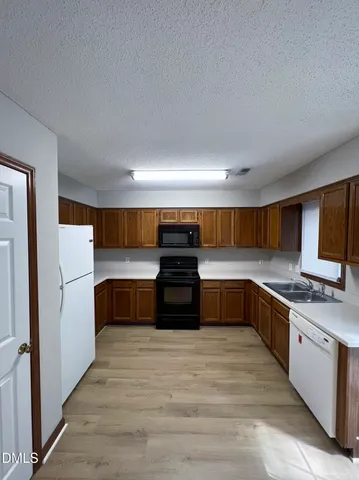 a kitchen with stainless steel appliances a stove a refrigerator and a sink