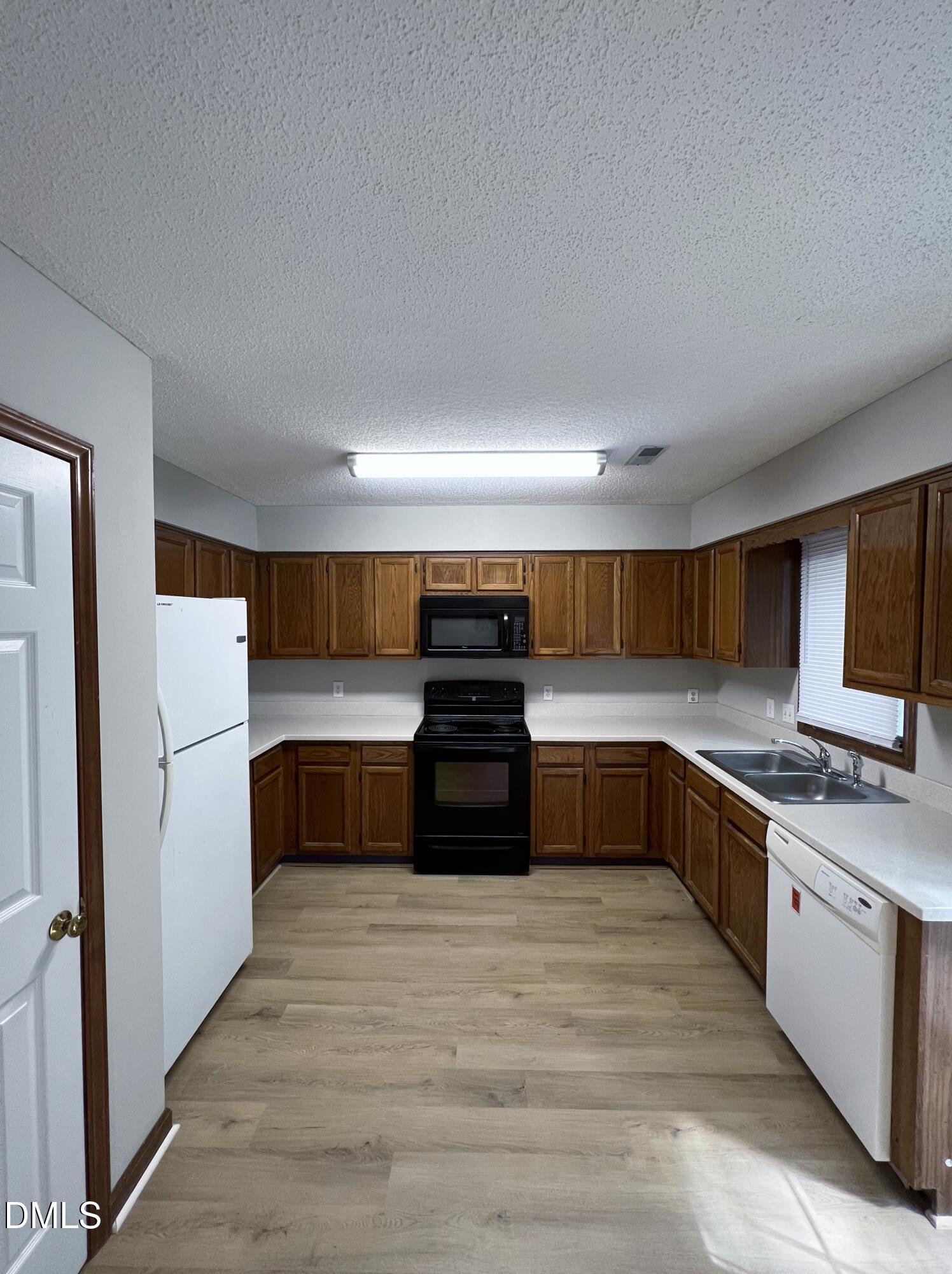 4305 Hunters Club Drive Raleigh, NC 27606 - Photo 4 of 12 a kitchen with stainless steel appliances a stove a refrigerator and a sink