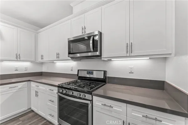 a kitchen with stainless steel appliances granite countertop a sink a stove and a refrigerator