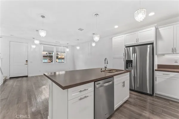 a kitchen with stainless steel appliances granite countertop a sink a stove and a refrigerator