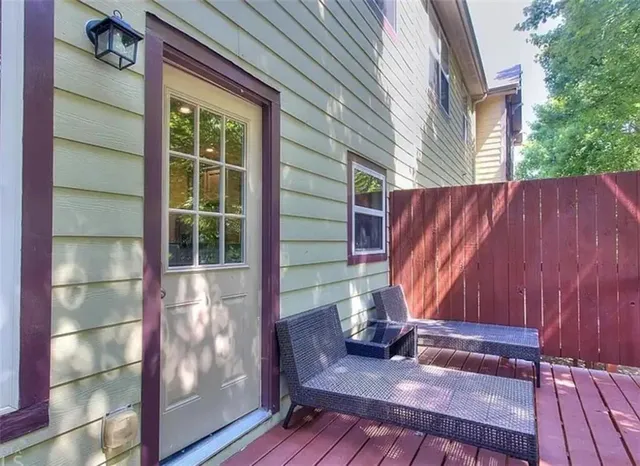 a view of a deck with a table and chair with wooden floor and fence