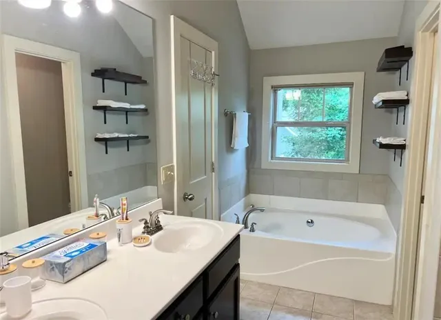 a bathroom with a tub sink and mirror