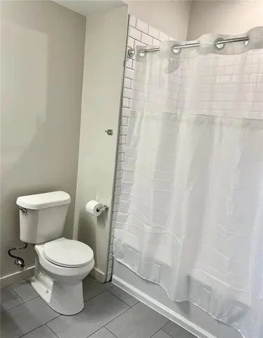 a white toilet sitting next to a shower