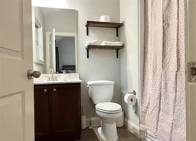 a bathroom with a toilet a sink and mirror