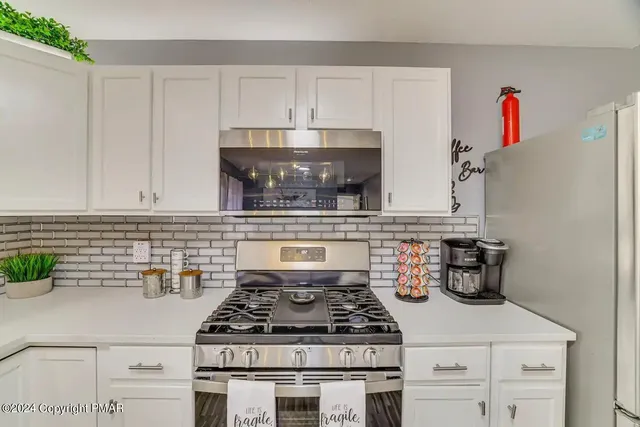 a kitchen with white cabinets and appliances