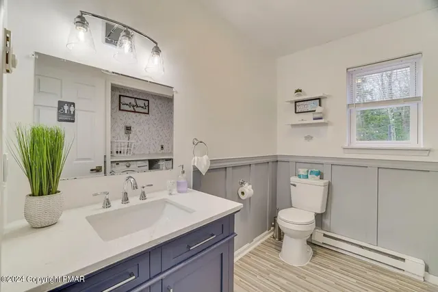 a bathroom with a sink toilet and mirror