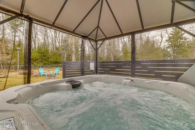 a view of an empty room with wooden floor and a table