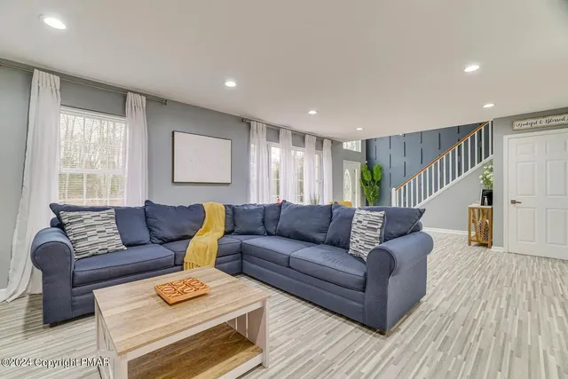 a living room with furniture and a wooden floor