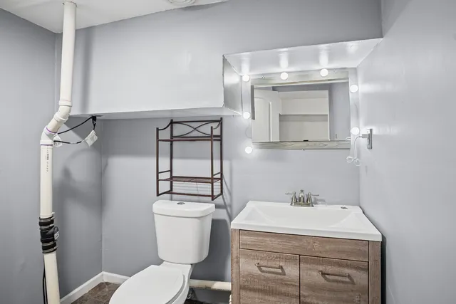 a bathroom with a sink a toilet and mirror