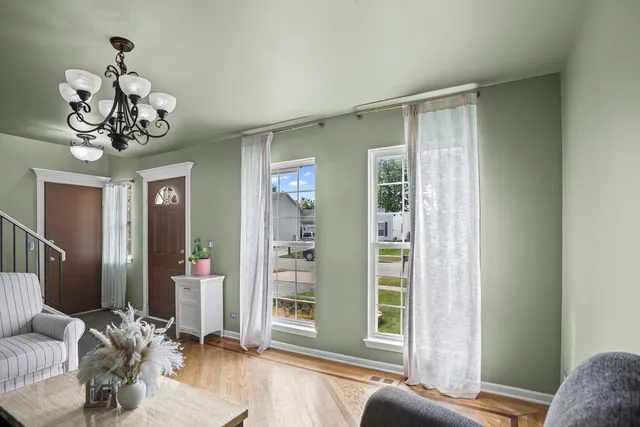 a view of a livingroom with a chandelier furniture and windows