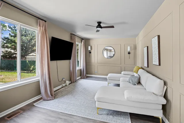 a living room with furniture a flat screen tv and a large window