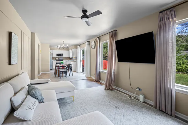 a living room with furniture a flat screen tv and a large window