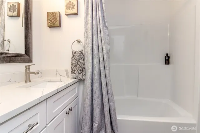 a bathroom with a granite countertop sink a toilet and bathtub