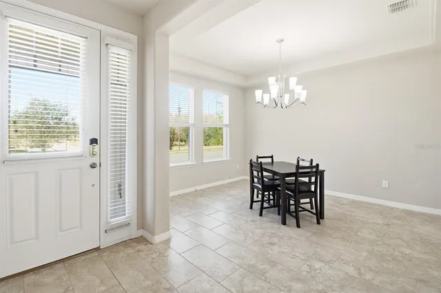 a view of a dining room with furniture and chandelier