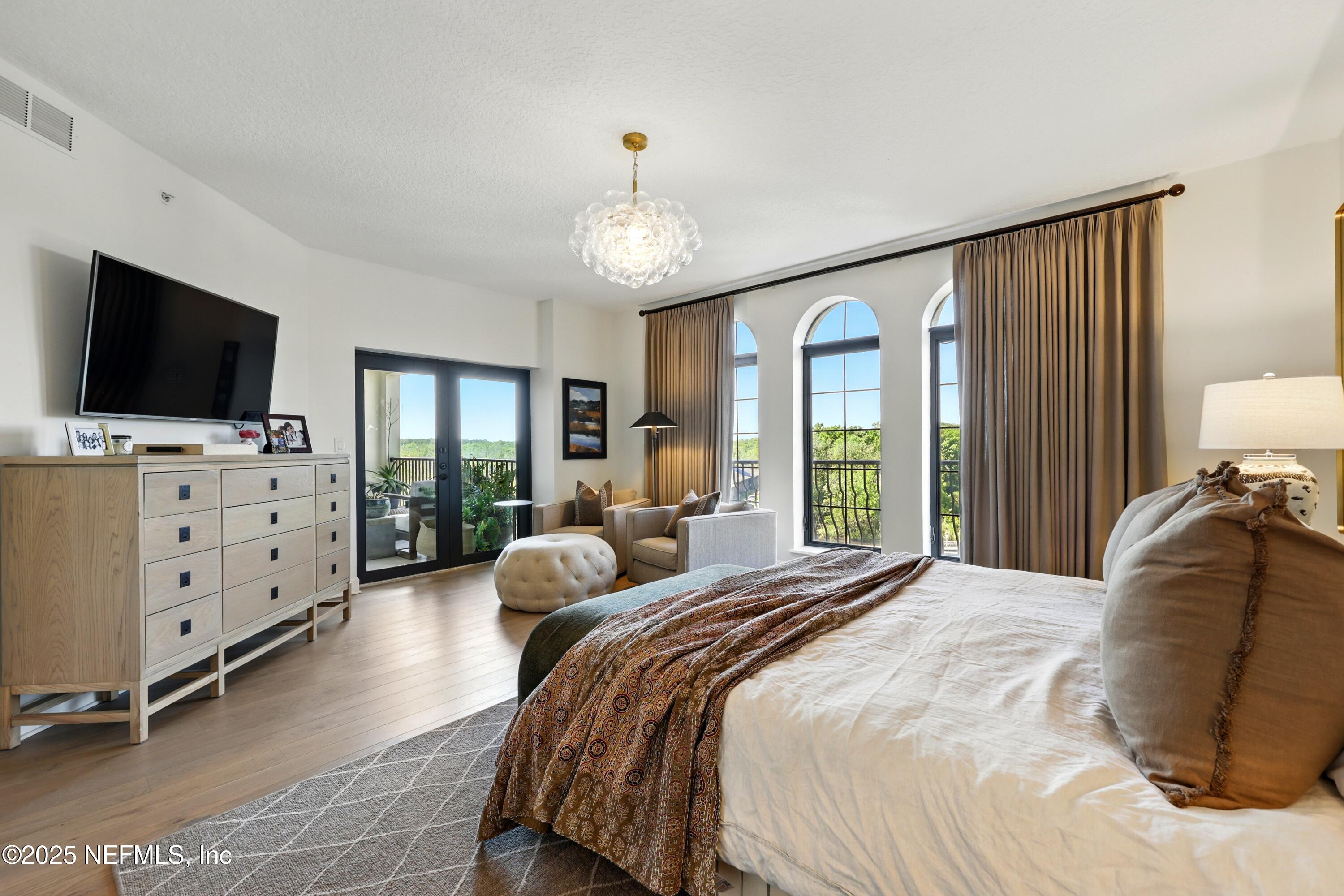 3958 Baymeadows Road, Unit 1602 Jacksonville, FL 32217 - Photo 29 of 89 a spacious bedroom with a bed and a flat screen tv on the dresser