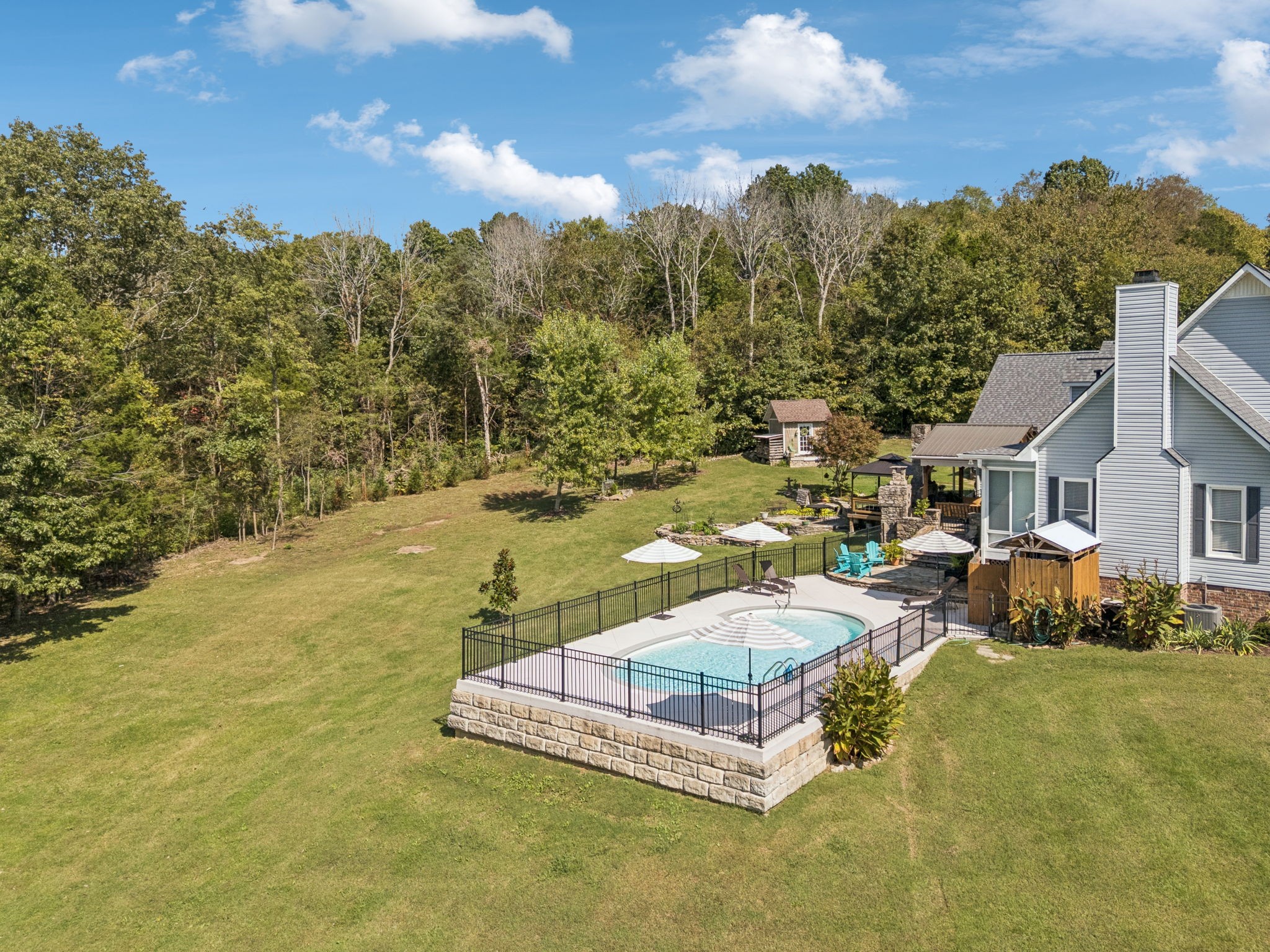 1909 Dr Robinson Rd Spring Hill Thompson's Station, TN 37179 - Photo 59 of 72 a view of a swimming pool with lawn chairs under an umbrella