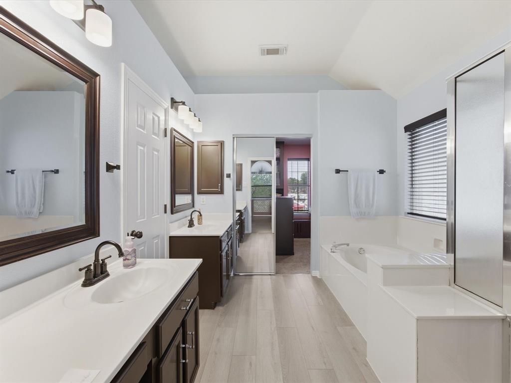 4008 Falcon Ridge Drive Haltom City, TX 76137 - Photo 24 of 40 Dual vanity with white countertops, dark wood-finish cabinetry, and oil-rubbed bronze fixtures