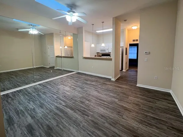 a view of a room with wooden floor and a kitchen