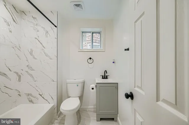 a white toilet sitting next to a bathroom sink