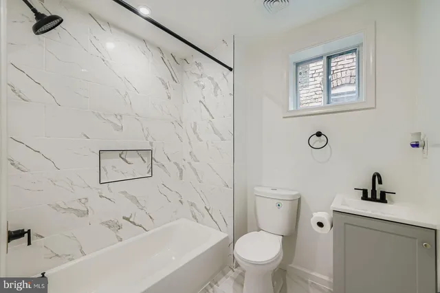 a bathroom with a toilet and a tub