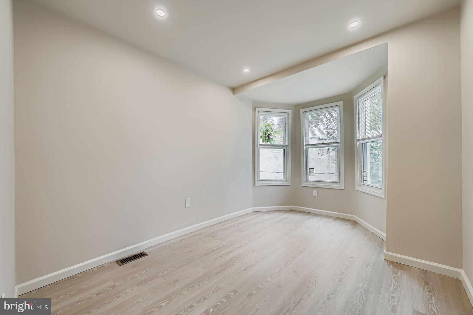 1729 North Fulton Avenue Baltimore, MD 21217 - Photo 18 of 30 an empty room with wooden floor and windows