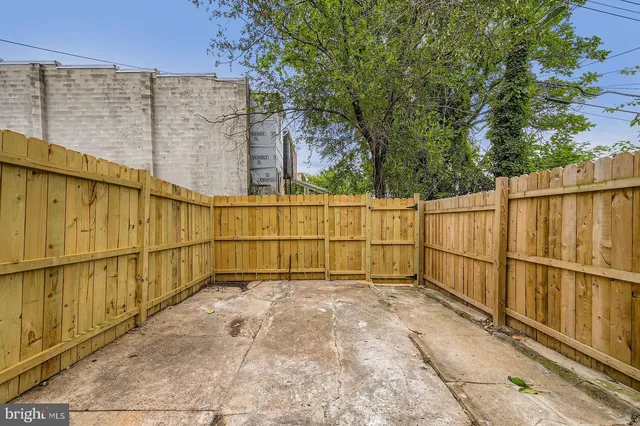 a view of a house with a wooden fence and a large window