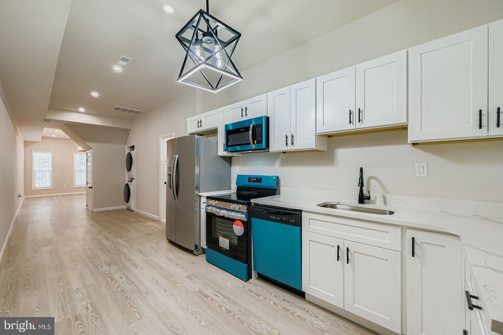 1729 North Fulton Avenue Baltimore, MD 21217 - Photo 7 of 30 a kitchen with stainless steel appliances granite countertop a refrigerator a sink dishwasher a stove and white cabinets with wooden floor