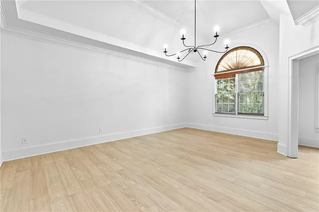 a spacious bedroom with a bed and a chandelier