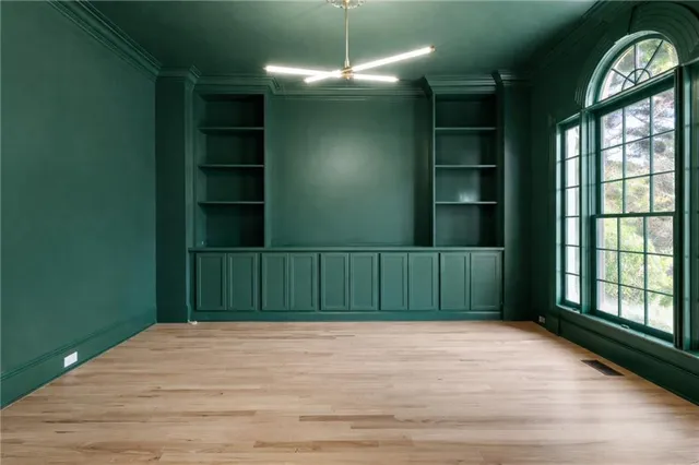 a view of empty room with window and wooden floor