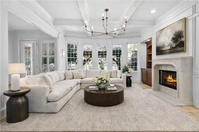 a living room with furniture a fireplace and a chandelier