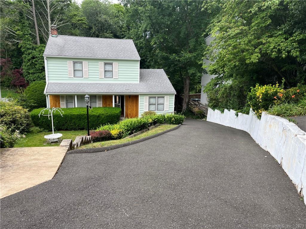 a view of a house with a yard and large tree