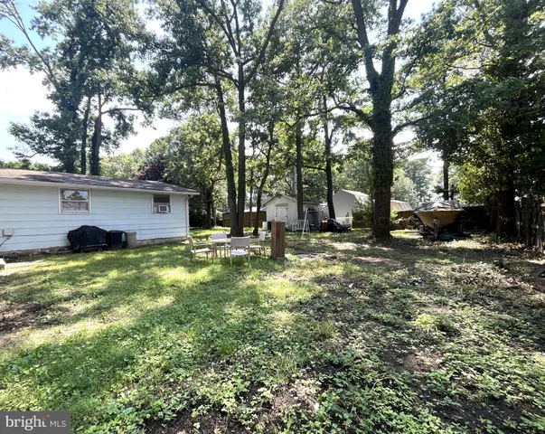 a view of a backyard with a garden and entertaining space