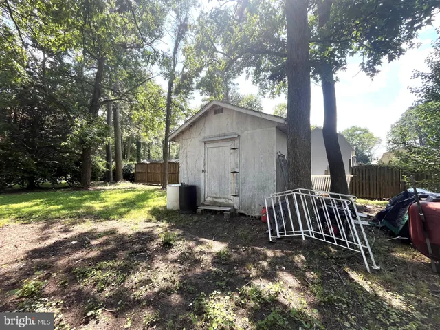 a view of a yard in front of a house with large trees