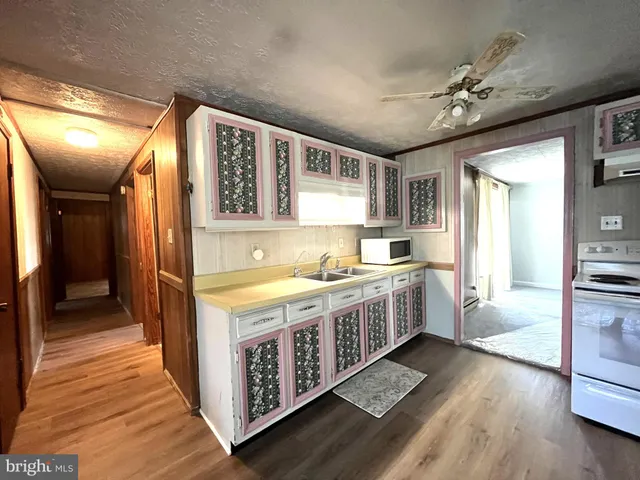 a large kitchen with a stove and wooden floor
