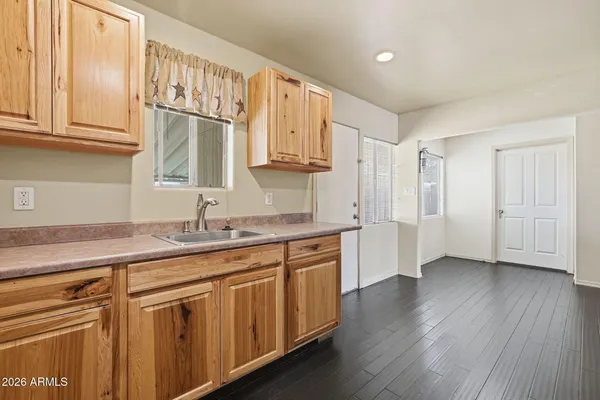 a kitchen with granite countertop a sink cabinets stainless steel appliances and a counter space