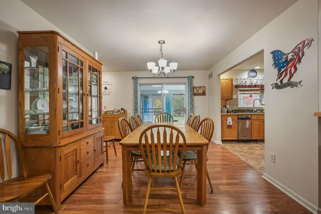 a dining room with furniture a chandelier and wooden floor