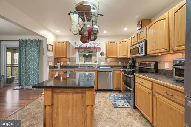 a kitchen with stainless steel appliances granite countertop a sink a stove and cabinets