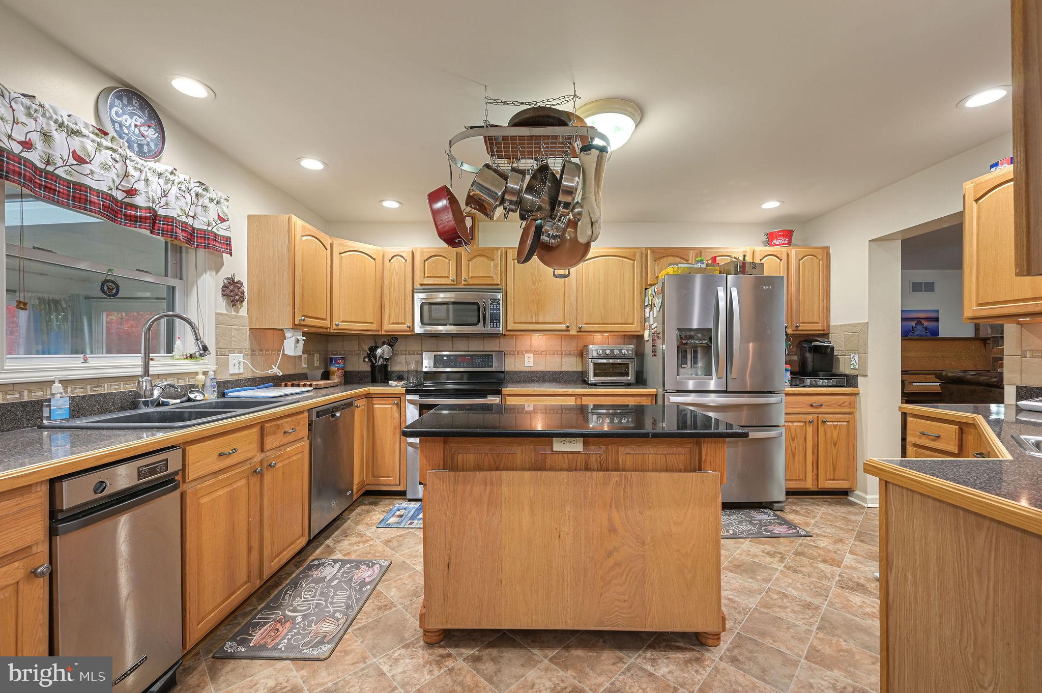 850 Arthursville Road Hartly, DE 19953 - Photo 15 of 35 a kitchen with stainless steel appliances granite countertop a sink a stove and a refrigerator