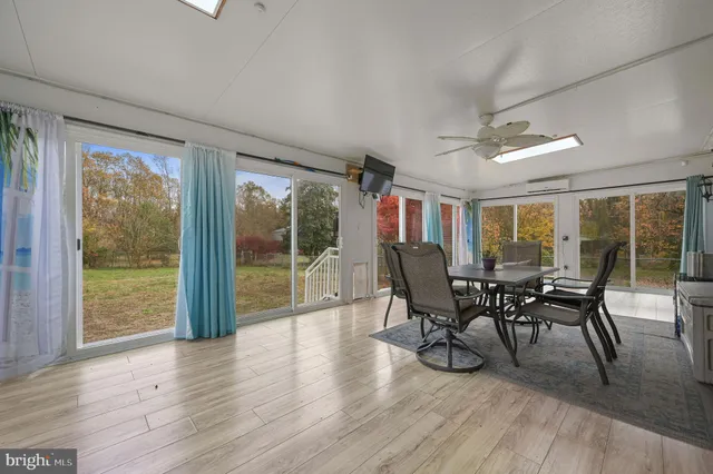 a dining room with furniture window and wooden floor