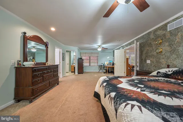 a bedroom with a large bed and a flat tv screen on dresser