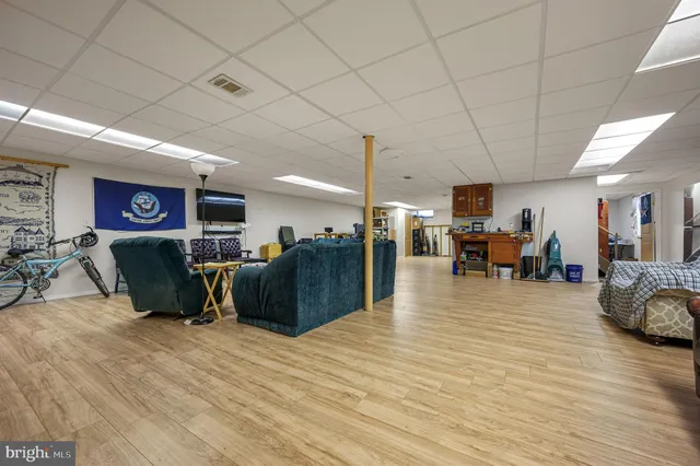 a living room with furniture a wooden floor and a flat screen tv