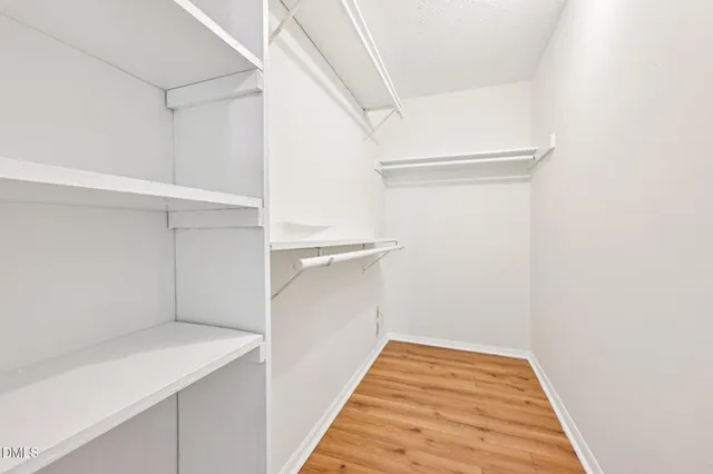a view of walk in closet with empty racks