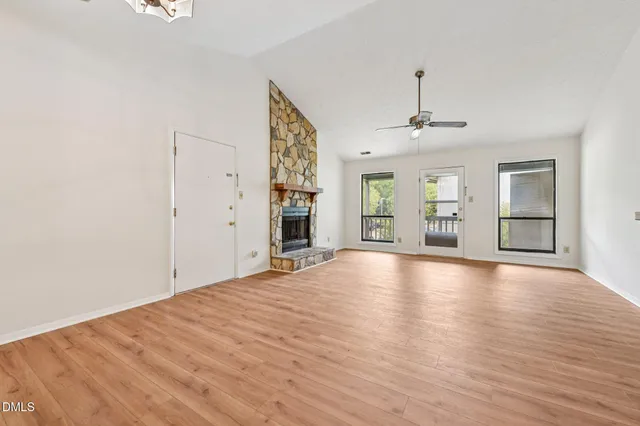 a view of empty room with wooden floor and windows