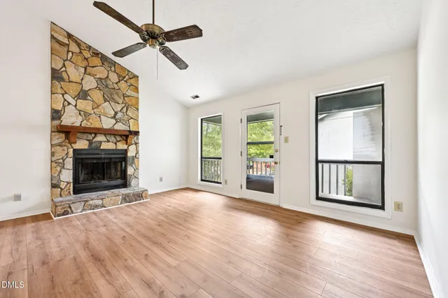 an empty room with windows and fireplace