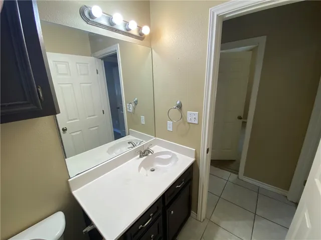 a bathroom with a sink a toilet a mirror and vanity