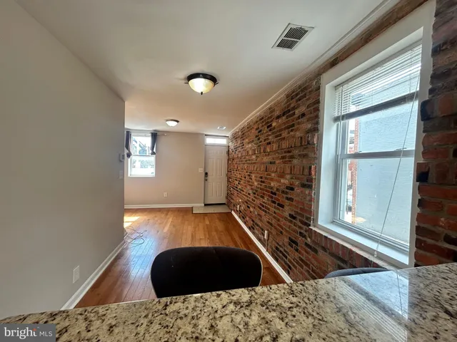 a view of a livingroom with wooden floor and staircase