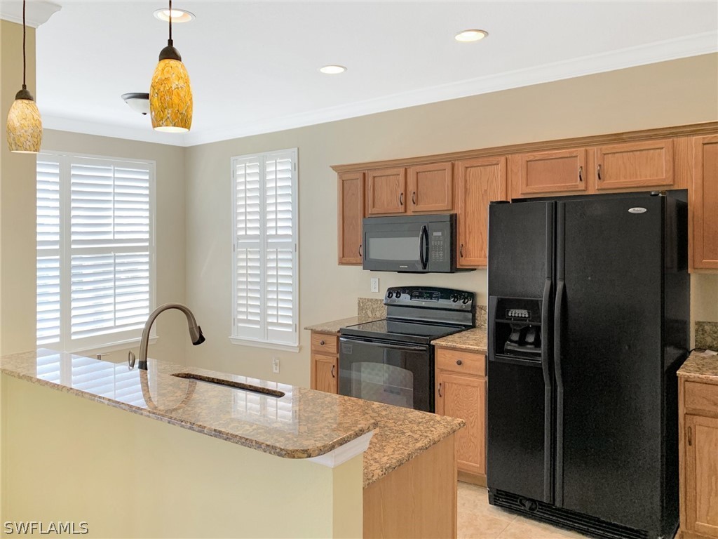 4100 Cherrybrook Loop Fort Myers, FL 33966 - Photo 8 of 25 a kitchen with stainless steel appliances granite countertop a sink a refrigerator and a stove