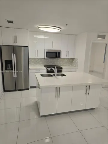 a kitchen with cabinets and steel appliances