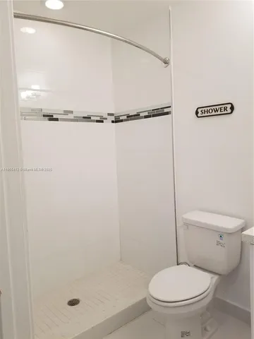 a bathroom with a toilet and a shower